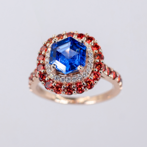 Anillo de tanzanita azul con rubíes y diamantes en oro rosa elegante